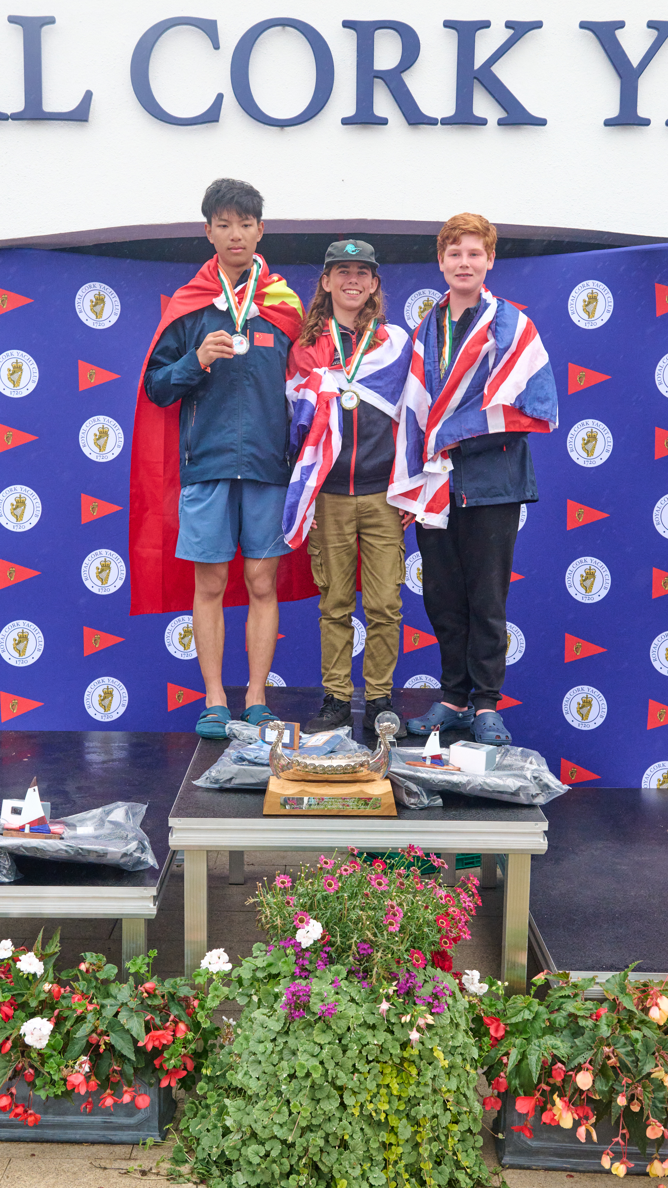 Topper World Champion 2023 Alex Jones (GBR) medalist on the Podium, with national flags wrapped around them